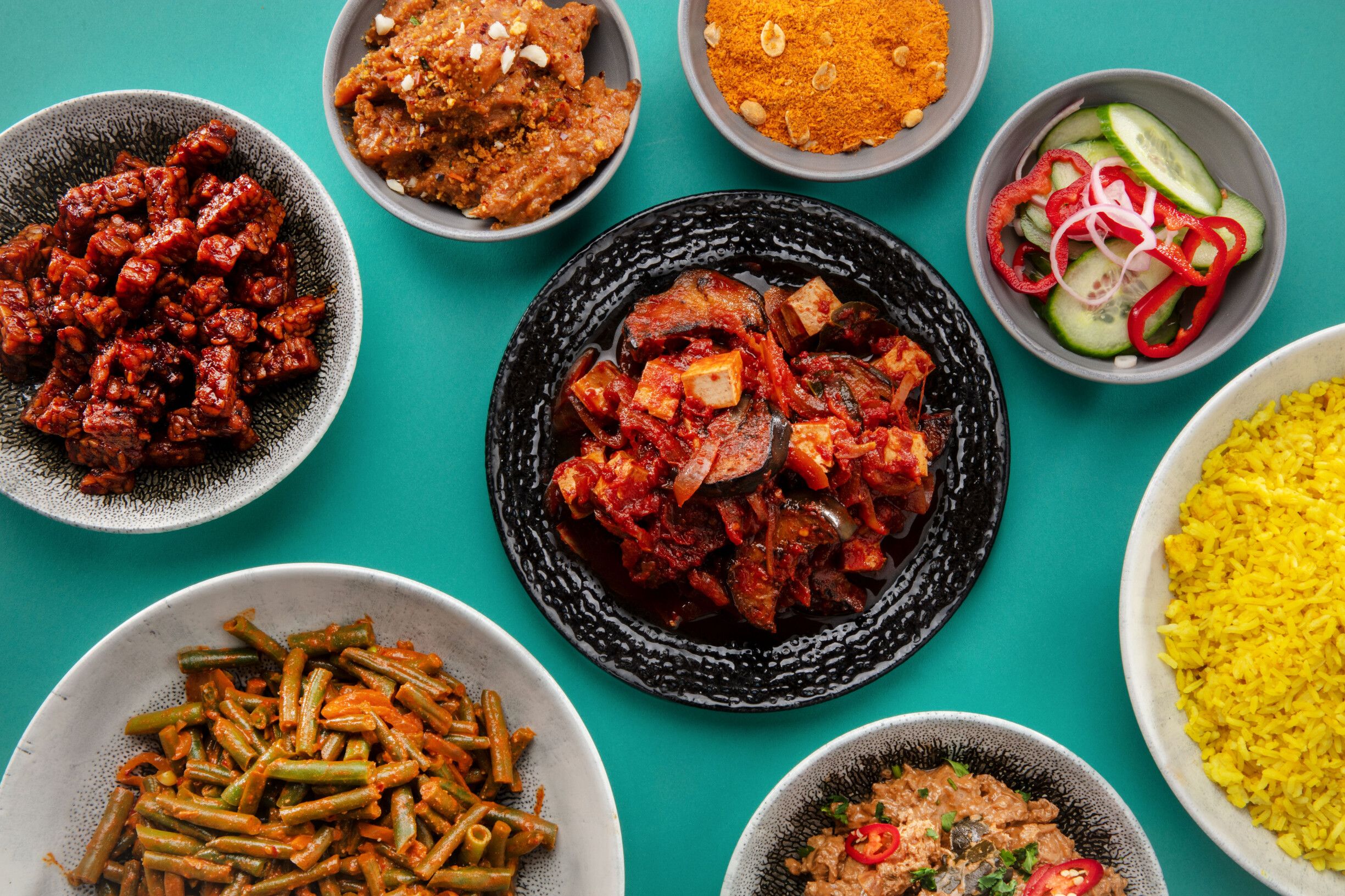 Smoor terong met nasi kuning, atjar ketimun en sambal goreng boontjes